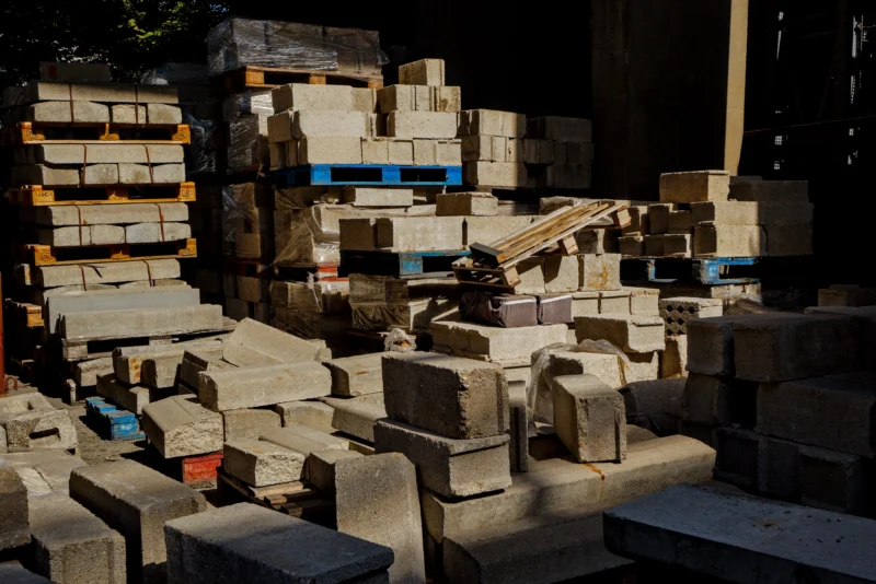 Frédéric · 14/06/2026 · 2517 x 1680 Cette photographie montre un **tas de blocs de béton ou de pierre** entassés de manière désordonnée. Le **sujet principal** est cette accumulation de matériaux bruts, évoquant un chantier ou un stockage.La **composition** est serrée, avec un **cadrage en plan serré**, mettant en valeur les textures et les formes anguleuses. La **lumière**, naturelle et tamisée, crée des ombres marquées, renforçant le côté brut et industriel. Les **couleurs dominantes** sont les tons gris-beige, avec quelques touches de bleu et d’orange sur certains éléments.Le **style** est documentaire et réaliste, tandis que l’**ambiance** est austère et industrielle, évoquant la robustesse et la rudesse des matériaux.