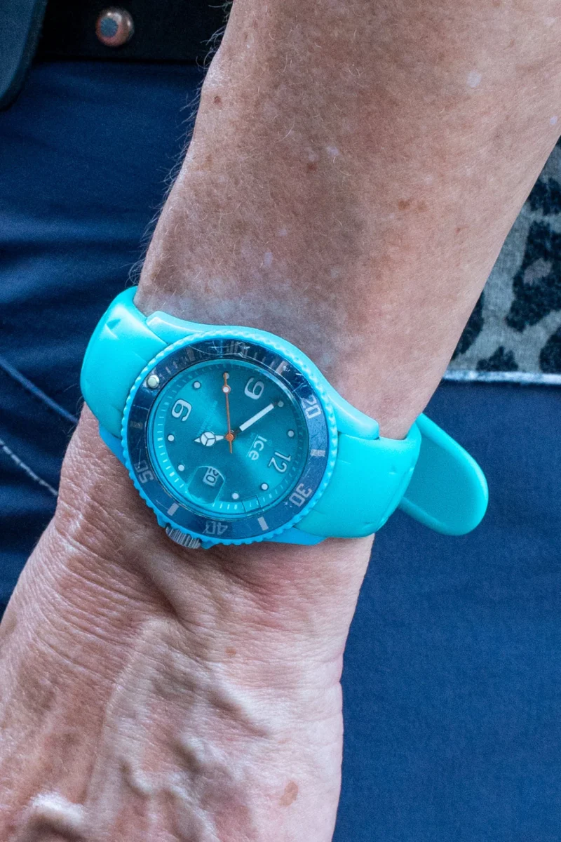 Marc L. · 20/06/2026 · 1271 x 1907 Cette photographie met en scène un **bracelet et un poignet** portant une **montre turquoise** comme sujet principal. Le cadrage est serré, centré sur le détail du poignet et de l'objet.La lumière semble naturelle, avec des ombres douces. Les **couleurs dominantes** sont le bleu turquoise vif de la montre et du bracelet, contrastant avec la peau et le tissu sombre en arrière-plan.Le style est simple et direct, axé sur le détail fonctionnel. L'ambiance est sobre et moderne, mettant en valeur l'objet avec une touche de minimalisme.