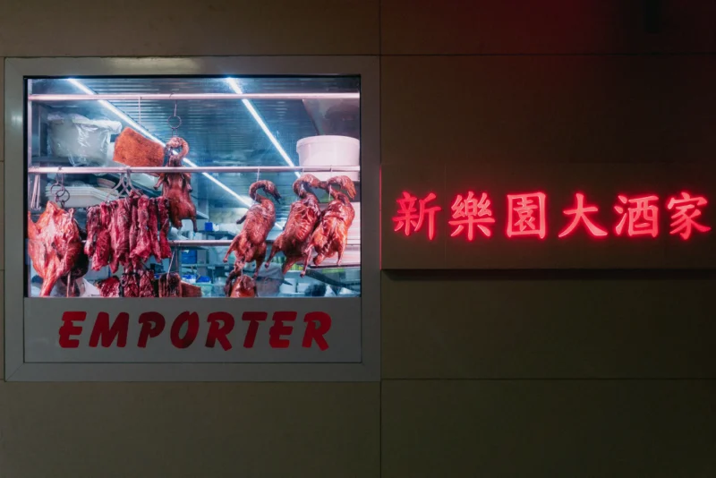 Daniel · 05/01/2018 · 4539 x 3029 Vitrine éclairée d'un restaurant affichant des carcasses de viande suspendues avec l'inscription 'Emporter' et