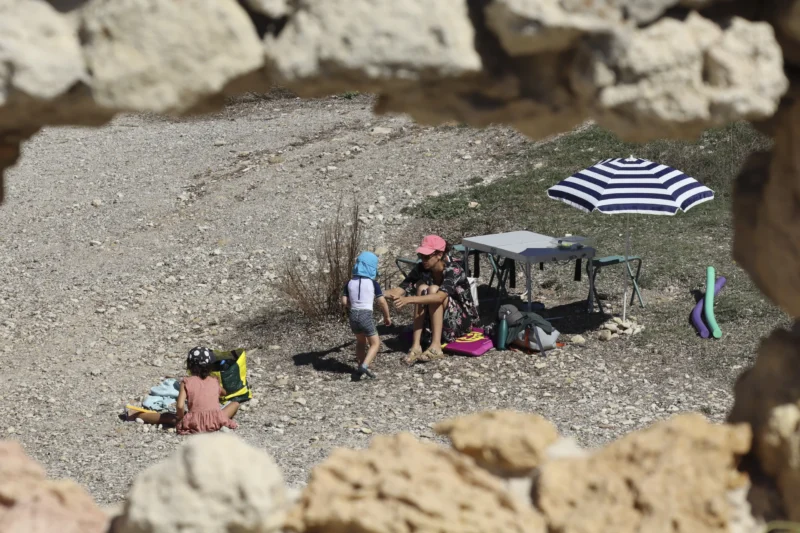 Camilla · 30/08/2026 · 3840 x 2560 Un groupe de personnes en tenue de randonnée ou de loisirs près d’un point d’eau, avec des accessoires de camping et