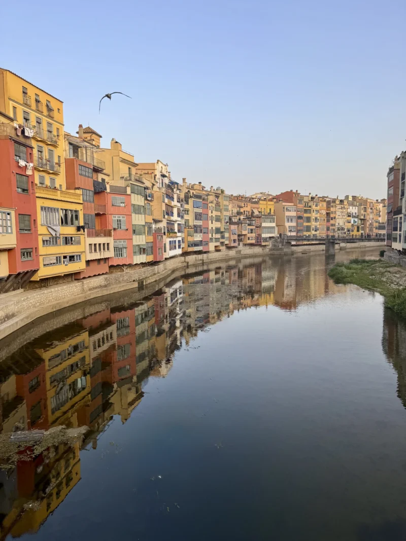 Heike · 16/07/2026 · 1500 x 2000 Vue d'un canal bordé de maisons colorées aux façades reflétées dans l'eau calme, ambiance paisible en journée