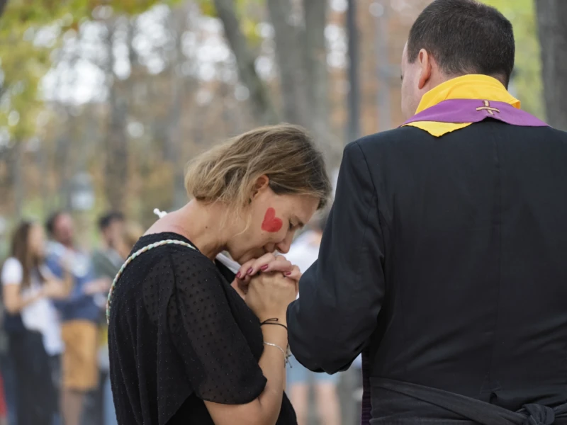 Thierry · 26/09/2026 · 3840 x 2560 Deux personnes en tenue formelle, dont l'une porte une cravate aux couleurs vives, semblent échanger un geste affectueux