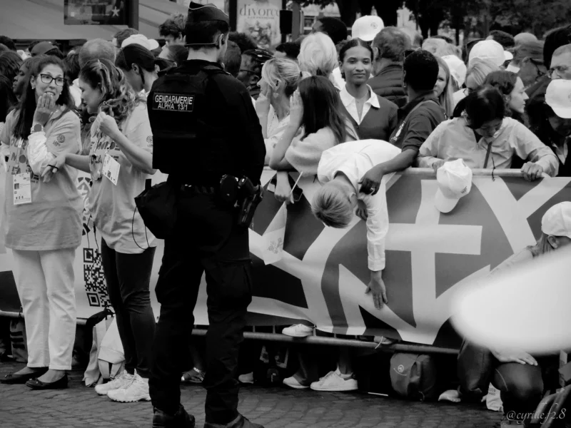 Cyrille · 26/09/2026 · 2026 x 1519 Manifestation avec des participants derrière une barrière tenant une bannière à croix gammée, un policier en uniforme