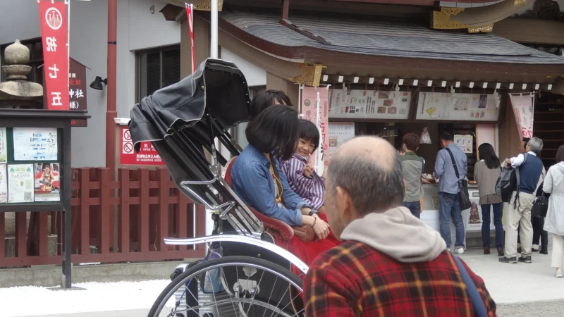 Bao · 22/10/2016 · 1920 x 1080 Deux personnes assises sur un vélo à pédales couvert, avec un homme en arrière-plan dans une rue animée près d’un bâtiment