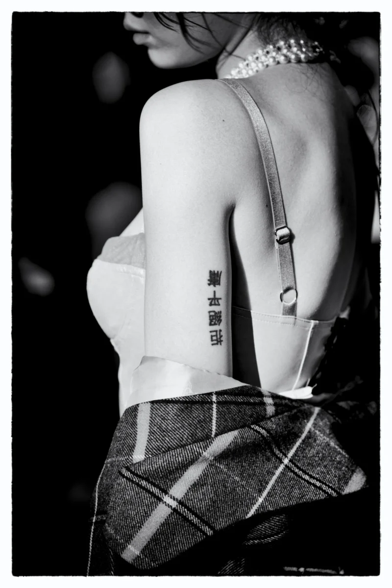 Silhouette dos nu avec tatouage et vêtement plaid, vue de trois-quarts en noir et blanc, ambiance intimiste