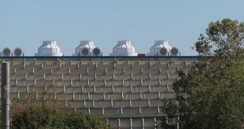 Jean paul · 05/10/2026 · 2400 x 1271 Bâtiment moderne avec une façade en damier et des ventilateurs sur le toit sous un ciel dégagé