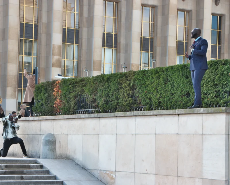 Jean paul · 19/11/2023 · 2400 x 1932 Statue imposante d’un personnage en costume sur un socle devant un bâtiment officiel, avec des visiteurs prenant des photos.