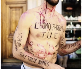 Thierry · 03/10/2026 · 1600 x 2400 Un homme torse nu avec des inscriptions peintes et des faux saignements sur la peau, posant devant un bâtiment en extérieur