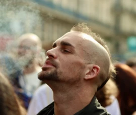 Francoise · 03/10/2026 · 2400 x 1600 Un homme avec une coupe de cheveux courte sur la tête, levant les yeux vers le haut dans une foule en extérieur, expression