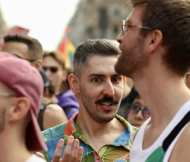 Francoise · 03/10/2026 · 2400 x 1600 Groupe de personnes en conversation lors d'une manifestation colorée, avec des expressions variées et des vêtements festifs