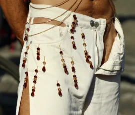 Francoise · 03/10/2026 · 2400 x 1600 Personne portant un pantalon blanc orné de franges et de perles colorées, style décontracté et artistique, vue rapprochée