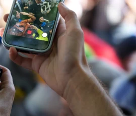 Marc · 03/10/2026 · 1080 x 1080 Une personne filme un groupe de personnes avec un smartphone, montrant des options de cadrage et de prise de vue à l'écran.