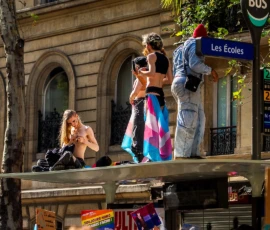 Marc · 03/10/2026 · 1080 x 1080 Manifestation urbaine avec des personnes sur un bus, brandissant des pancartes et des drapeaux, devant un bâtiment classique