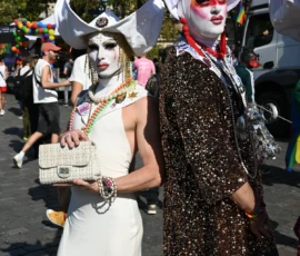 Aurélie · 1494 x 2048 Deux personnes déguisées en costumes fantaisistes et maquillées de blanc participent à une parade colorée en extérieur