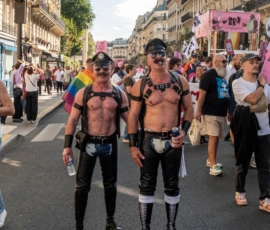 Léonard · 03/10/2026 · 2400 x 2225 Deux personnes participant à une manifestation colorée en ville, vêtues de tenues fétichistes et accessoirisées, entourées