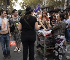 Alice · 03/10/2026 · 2400 x 1600 Groupe de personnes en pleine rue discutant près d’un chariot rempli de fournitures, lors d’une manifestation ou événement