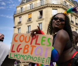 Muriel · 03/10/2026 · 2048 x 1365 Manifestation pour les droits des couples LGBTQI+ avec un panneau contre l'homophobie, ambiance colorée et urbaine.