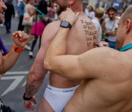 Frédéric · 03/10/2026 · 2400 x 1602 Trois personnes en sous-vêtements ou presque, dont une avec un message écrit sur l'épaule, participant à une manifestation