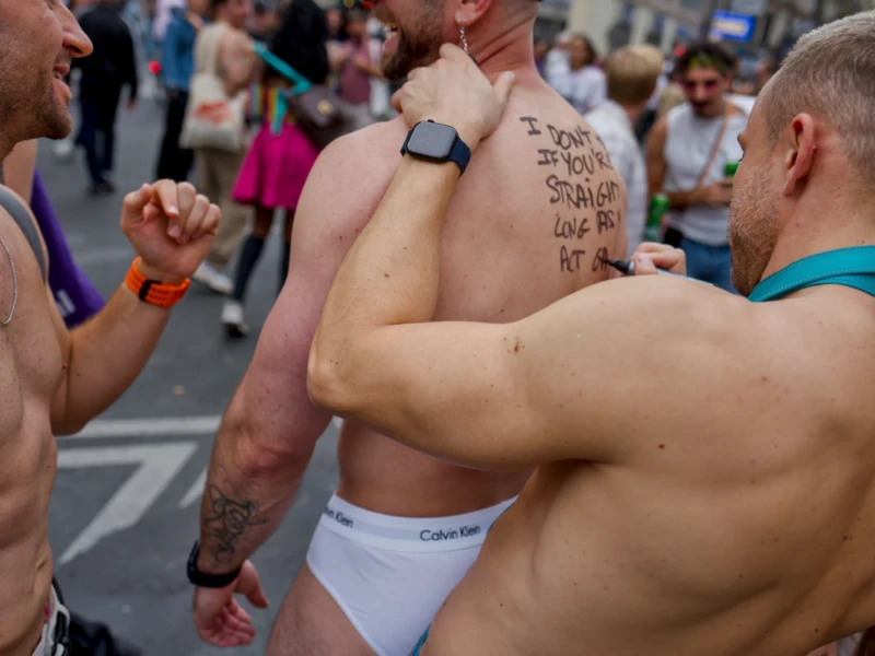 Frédéric · 03/10/2026 · 2400 x 1602 Trois personnes en sous-vêtements ou presque, dont une avec un message écrit sur l'épaule, participant à une manifestation